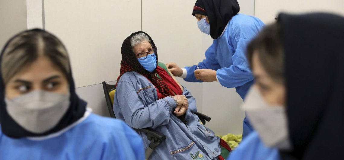 A nurse injects a COVID-19 vaccine into a patient's arm in Iran