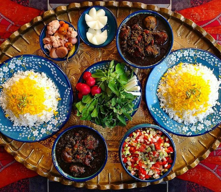 A mouthwatering plate of Persian food featuring Ghormeh Sabzi, a traditional stew made with herbs, meat, and kidney beans, served with fluffy saffron rice.